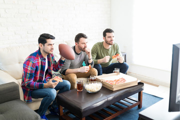 Group Of Sport Fans Watching Match In Living Room