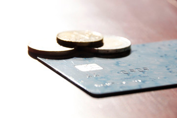 some coins and a card in a sunny day over a table