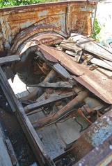 Close-up of transmission and remnants of a wooden body of an old rusty pickup truck, Rhodes Island, Greece