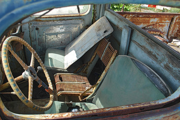 Close-up of the steering wheel and seats in the cab of an old rusty pickup truck, Rhodes Island, Greece