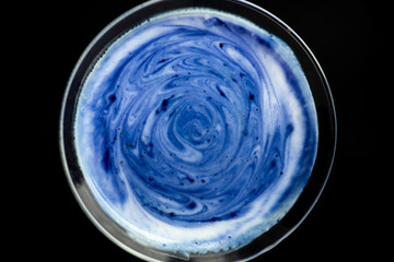 Blue matcha latte on a black background, top view