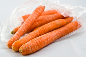 Carrots in plastic bag isolated on white