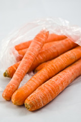 Carrots in plastic bag isolated on white