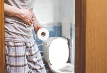 A man holds toilet paper. Diarrhea. Constipation concept. 