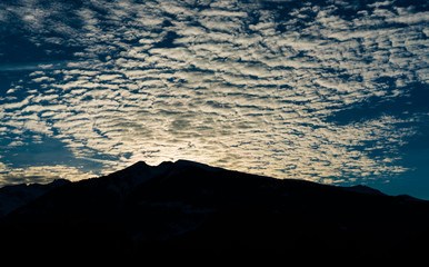 silhouette mountain landscape winter evening with fantastic cloudscape
