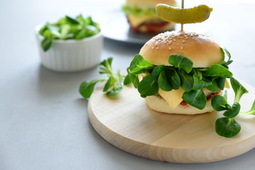 Tasty homemade vegan burgers with vegetables and greens on gray wooden background. Copy space