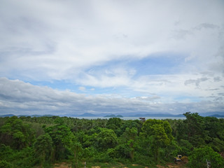 Obraz premium Green jungle and sea in the distance under a cloudy sky, Thailand.