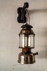 Antique oil lamp hanging on a white wall