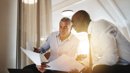 Two businessman discussing paperwork together in an office