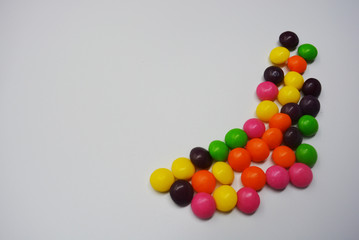 A lot of round sweets like tablets, medicine with bright color and taste. This color sweets are round beads, rainbow color stones. It's popular delicious colorful sweet with sweaty and lively form.