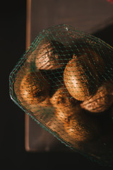 Close up of sunbathe kiwifruits in a plastic basket.