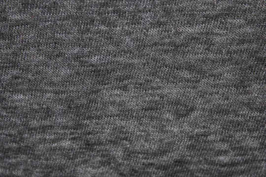 Gray fabric texture background of dark grey colored shirt. Cloth surface  and material design for empty backdrop, modern fashion clothes simple  pattern. Blank apparel canvas and copy space Stock Photo