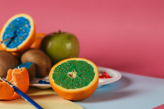 Different kinds of fruit photographed on colorful background and painted with different colours.