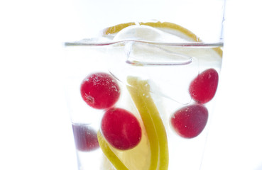 cold Summer refreshing cocktail with lemon pieces of ice and berries. photo summer drink close-up on a white background.