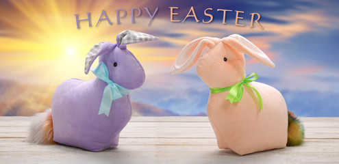 Two Easter bunnies with happy easter inscription. Easter holiday concept.