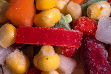 Homemade mixture of frozen vegetables, macro close-up background. Carrot, paprika, beans, green beans, onion and corn.