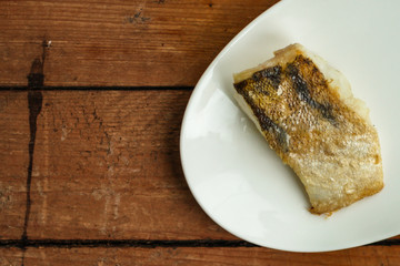 Fish, fried seafood (white fish on the plate). Food background