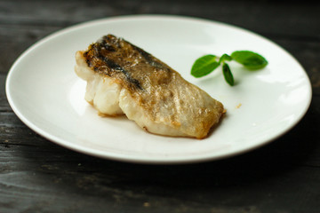 Fish, fried seafood (white fish on the plate). Food background