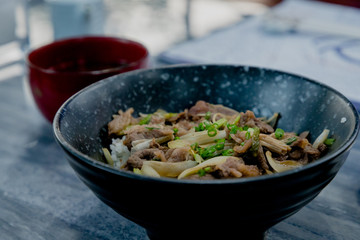 Gyudon; Japanese beef with rice bowl, close up shot with miso soup in Japanese style restaurant. 
