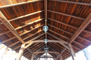 ceiling wooden roof of the street arbor with lamps