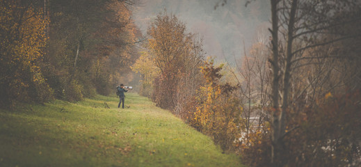 Young man devoting time to his favorite hobby - photography - taking photos outdoor with his...