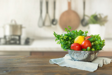 Modern kitchen with fresh vegetables on wooden tabletop, space for you and display products.