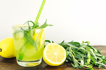 Healthy summer drink. Homemade lemonade. Refreshing cocktail. Ingredients: tarragon, lemon, soda, sugar.