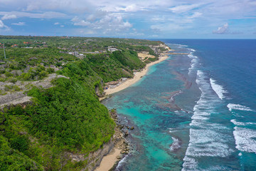 Tropical beach with high green cliffs, aerial view, Melasti beach, Bali, Indonesia