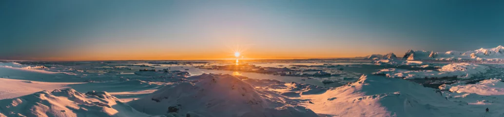 Foto op Aluminium Helder kleurrijk zonsondergangpanorama in Antarctica. Oranje zonlicht over het met sneeuw bedekte polaire oppervlak. Pittoresk winterlandschap. De schoonheid van de wilde ongerepte Antarctische natuur. © Goinyk