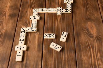 The concept of games of dominoes. Playing dominoes on a wooden table.