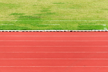 Obraz premium Natural green grass field and orange Running Track background. Success concept or target goal concept.