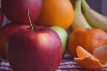 Bananas, apples, lemon, orange on table