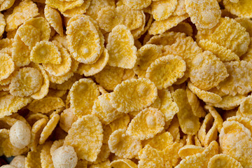Texture of dry, frosted, glazed yellow corn flakes for cereals breakfast.