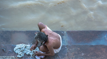 Hombre de espaldas lavando ropa en el río Ganges, en Varanasi, India. Foto Aérea