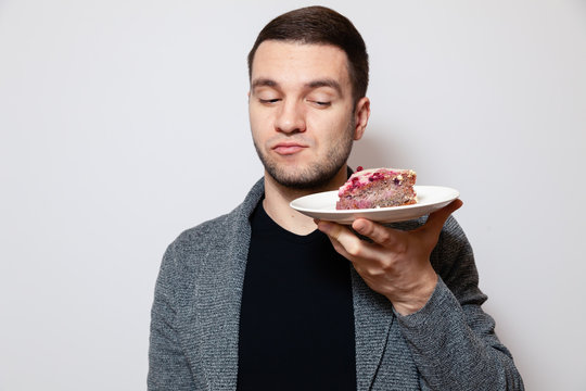 Closeup Portrait Young Cute Caucasian Man Holding White Round Plate With Piece Of Biscuit Cake, Preparing To Eat It, Grinning. Concept Sweet Lover, Sugar Addiction, Eat Too Much