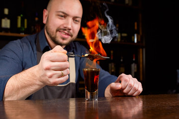 Fiery show at the bar. The bartender makes hot alcoholic cocktail and ignites bar. Bartender...