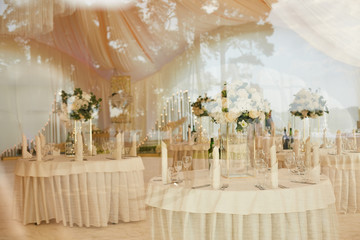 Banquet room in the tent during the wedding ceremony shot through the glass