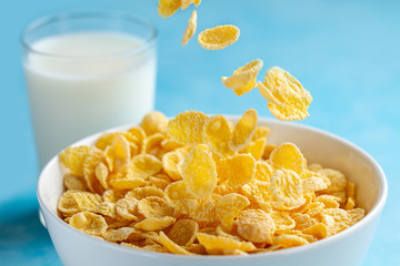 Yellow frosted corn flakes bowl and a glass of milk for dry, cereals breakfast
