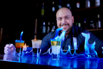 Fiery show at the bar. The bartender makes hot alcoholic cocktail and ignites bar. Bartender prepares a fiery cocktail. Fire on bar.