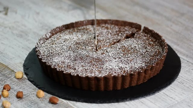 Cutting Homemade Dark Chocolate Tart On Rustic Background.