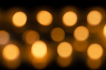 Obraz premium Many beautiful lit candles in a row glowing with a golden yellow light - selective focus