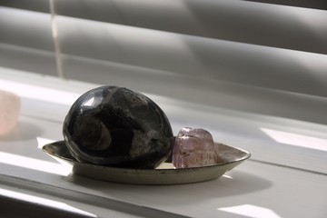 Mineral specimens in a silver tray on the windowsill