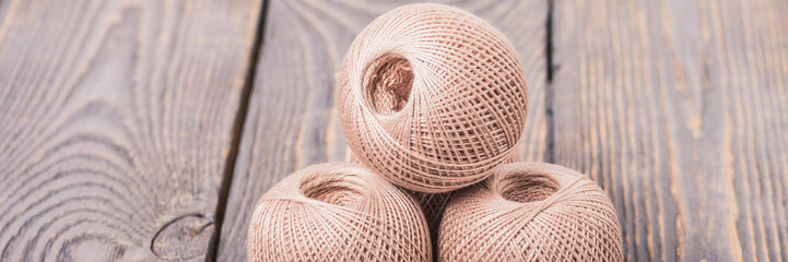 Balls of yarn thread for knitting on a wooden background.