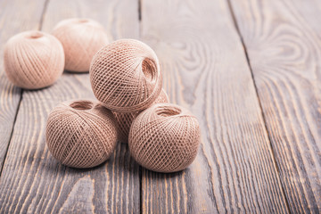 Balls of yarn thread for knitting on a wooden background.