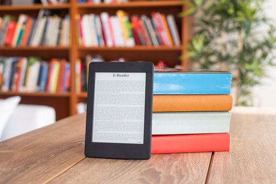Digital E-book Reader And Paper Books On Table