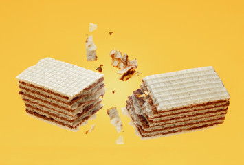 Chocolate crackle crispy wafers with crumbs on yellow background. Food and snack for sweet tooth