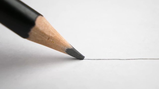 extreme close up of architect or artist draws a line in pencil. schoolboy drawing a flat line with a black pencil. Artists hands drawing wooden pencil writes line on paper. tracking shot