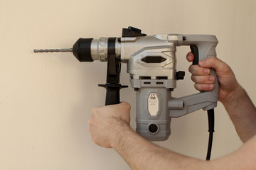 Power tool drill in male hands for a white background close-up.
