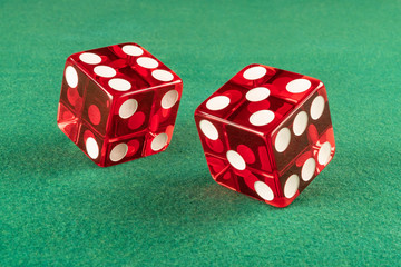 Red dice over green casino felt (w/clipping path). Great close up showing numbers 6 and 5 