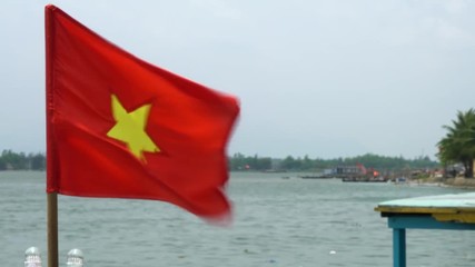 Vietnamese flag flying in the wind on a boat on the Thu Bon River, Hoi An, Vietnam, South East Asia